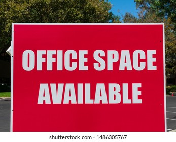 Office Space Available - Large Sign Near Vacant Commercial Building Advertising The Real Estate, Property, Office For Sale, Rent Or Lease.