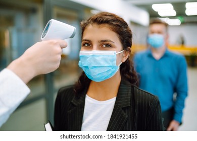 Office Staff Undergo Temperature Screening At The Entrance. Business People Back At Work In Office After Quarantine. Covid-19.