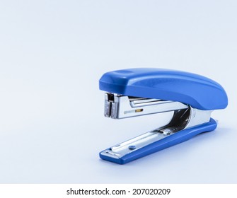 an office stapler with blue hand grip isolated on white background