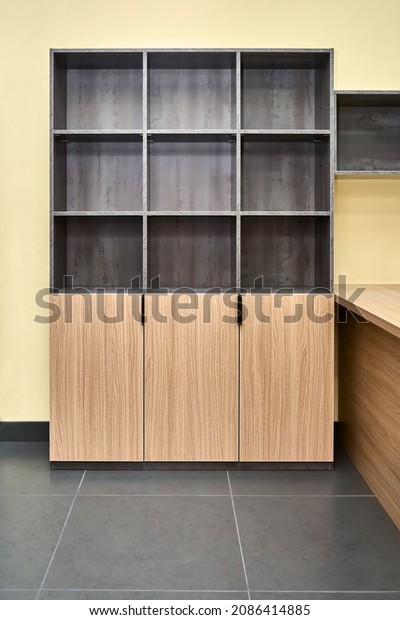 Office storage cabinet for documents with empty\
shelves made of laminated chipboard with wood and stone texture\
pattern in spacious\
office