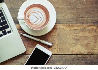 office stuff with laptop smartphone and coffee cup mouse notepad top view shot. - Powered by Shutterstock