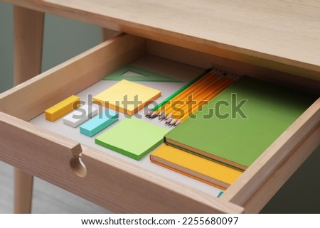 Office supplies in open desk drawer indoors, closeup