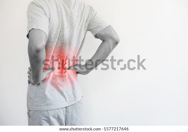 Office syndrome, Backache and\
Lower Back Pain Concept. a man touching his lower back at pain\
point