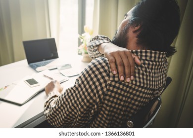 Office Syndrome Concept; Businessman Sitting At Office Desk,  Suffering From Backache After Working,man Touching Lower Back With Pained Expression.
