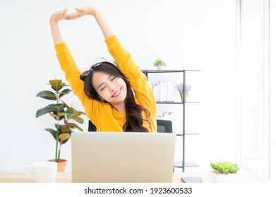 Office Syndrome Concept. Young Asian Woman Feeling Pain In Neck And Shoulder After Working On Computer Laptop For A Long Time. She Stretches To Relax Her Muscles