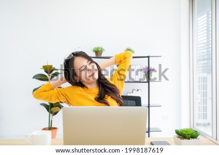 Office syndrome concept. Young asian woman feeling pain in neck after working on computer laptop for a long time
