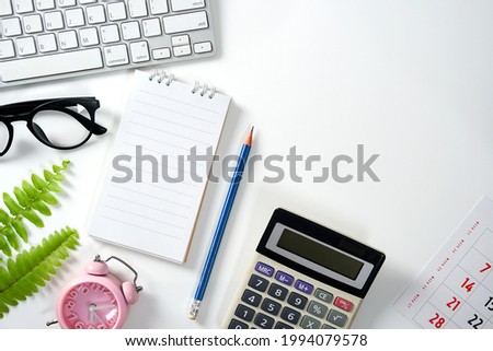 Office table with blank notebook, computer tools, Calculator, notebook, calendar, and office supplies. Top view with copy space, flat lay.      
