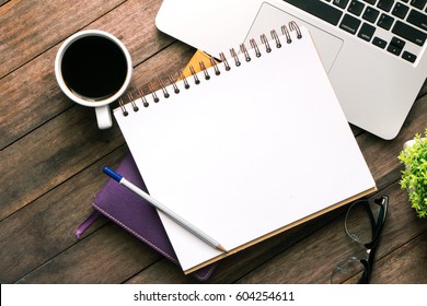 Office table with blank notebook and laptop / Coffee cup - Powered by Shutterstock