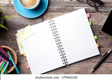 Office table with a coffee cup, a blank notepad and a plant - Shutterstock ID 279465143