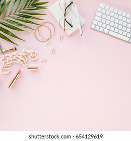 Office table desk with computer,  green leaves palm, clipboard. Magazines, social media. Top view. Flat lay. Home office workspace. Women's fashion accessories isolated on pink background.  - Shutterstock ID 654129619
