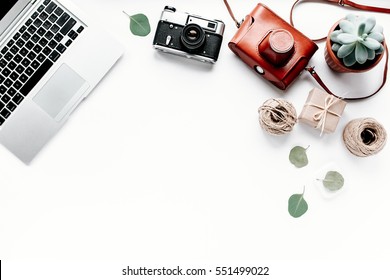 Office table desk. laptop, computer, camera, succulent. Flat composition, magazines, social media and artists. Top view, home office workspace - Powered by Shutterstock