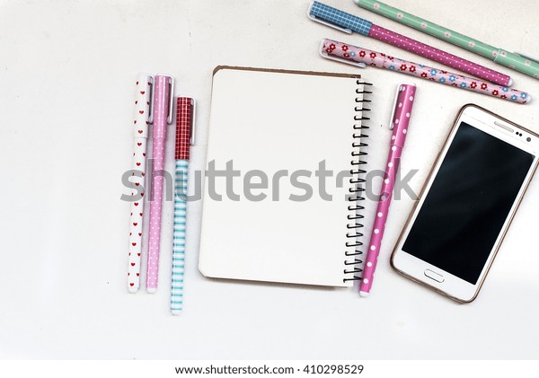 Office table desk\
with set of Office Stationery or  Supplies.. colored gel pens,\
laptop and notebook for entries\
