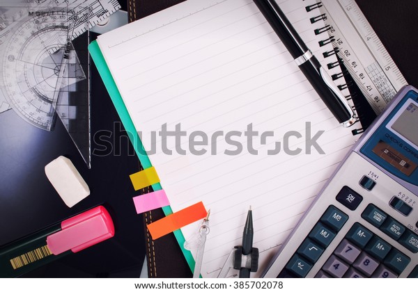 Office table desk or office workplace with\
paper note, note, notebook, calculator, office supplies and office\
equipment. School and office supplies over office table with copy\
space. Office supplies.