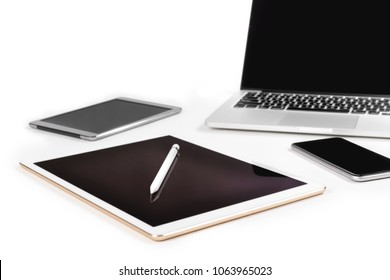 Office table with laptop computer, digital tablet, smartphone, pencil and mouse on isolated pure white background / Laptop and tablet mockup concept. (Selective Focus)