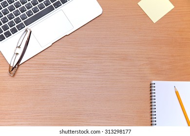 Office table with laptop, notepad and coffee cup. View from above with copy space - Shutterstock ID 313298177