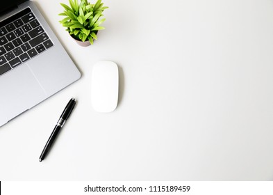 Office table with Laptop,mouse,pen and plant, copy space,Top view, flat lay,minimal style - Shutterstock ID 1115189459