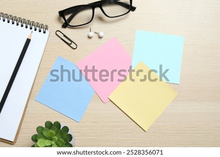 Office table with note stikers, pencil and plant, top view