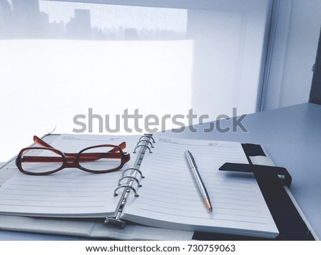 office table with notebook put a pen and glasses in modern office With coputer notebook