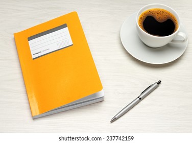 Office table with notepad, computer and coffee cup