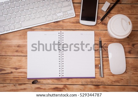 Office table with notepad, laptop and coffee cup.View from above with copy space.