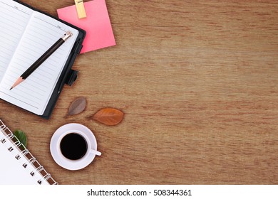 Office table with notepad, phone, computer and coffee cup. View from above with copy space