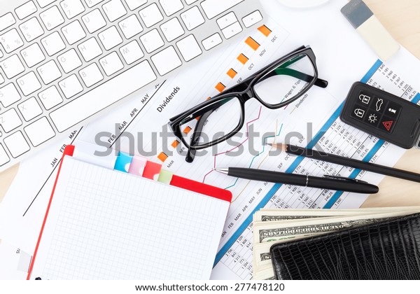 Office table with pc, supplies and money cash. View\
from above