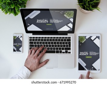 office tabletop with tablet, smartphone and laptop showing cool responsive digital agency website