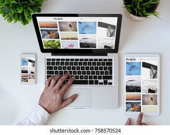 Office Tabletop With Tablet, Smartphone And Laptop Showing Photo Portfolio Website