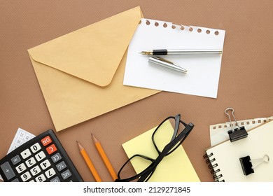 Office Top View With Notepad, Laptop Calculator Glasses Stickers. And Copy Space. Brown Background. Business Concept