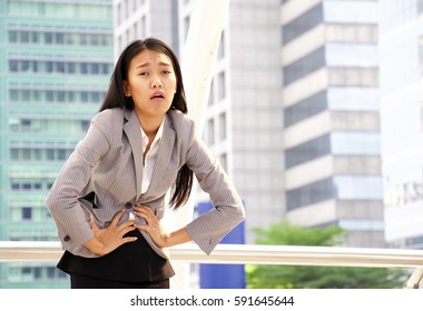 Office woman is having stomache from period or food poisoning body language with city background. - Powered by Shutterstock