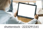 Office work. Digital mockup. Virtual technology. Unrecognizable woman working tablet computer with blank screen in light room interior.