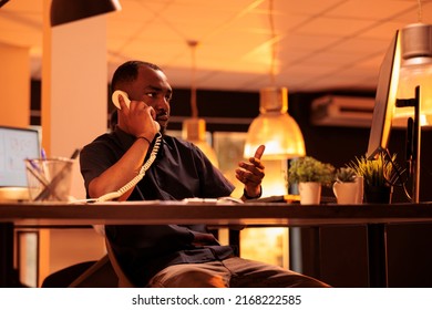 Office Worker Answering Landline Phone Call To Talk To Manager About Paperwork Report On Computer. Chatting On Office Telephone Line, Having Remote Conversation About Business Documents.