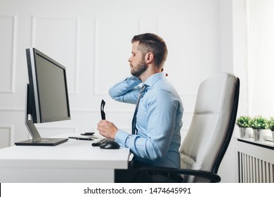 Office Worker With Back Pain From Sitting At Desk All Day