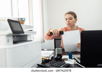 Office worker, business woman with stapler at her workplace in the office