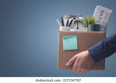 Office worker carrying personal belongings in a box after being fired, unemployment and career concept