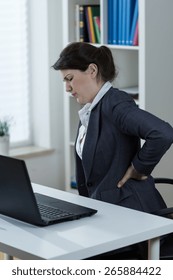 Office worker having backache caused by sedentary work