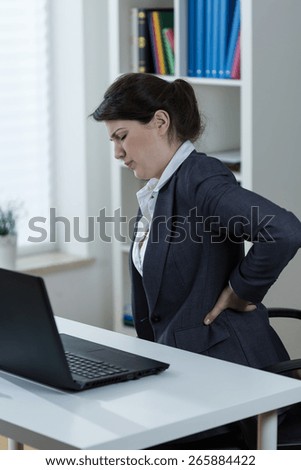 Office worker having backache caused by sedentary work