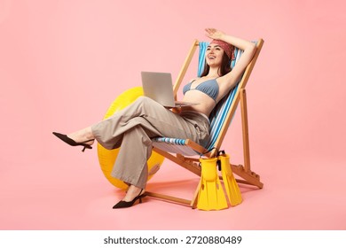 Office worker with laptop, inflatable ring and swimfins on deckchair against pink background