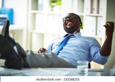 Office Worker Listening To Music At Workplace