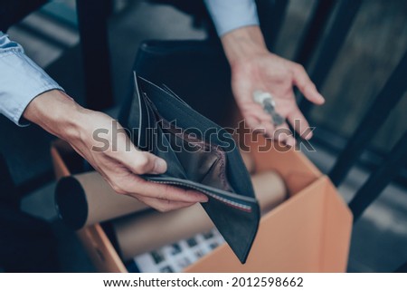 Office worker lost his job and open a wallet without money. Man empty wallet, man broke concept.
