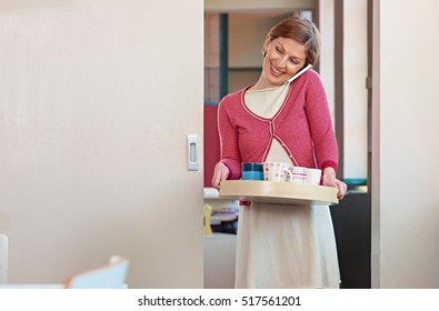 Office Worker On Cell Phone, Carrying Tea Tray