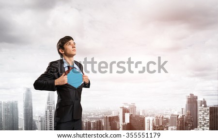 Office worker opening his shirt like superhero on modern city background