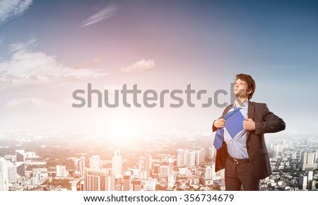 Office worker opening his shirt like superhero on modern city background