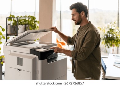Office worker operating a multifunction printer, highlighting modern office technology and workflow efficiency in a bright, plant-filled workspace. Office work concept
