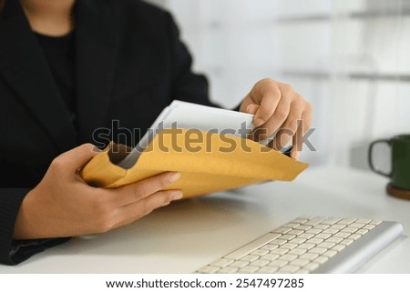 Office worker preparing documents in envelope for business transactions