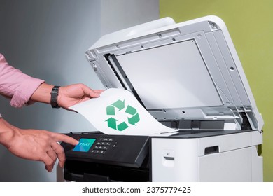 el trabajador de oficina imprime papel en una impresora láser multifunción con papel reciclado en documentos o papeleo de oficina en el hogar. el concepto del Día Mundial del Medio Ambiente y las actividades empresariales sostenibles.