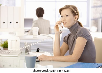 Office Worker Sitting At Desk, Talking On Landline Phone.?