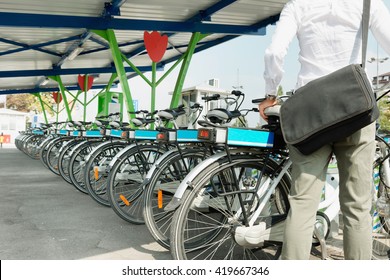 Office worker takes e-bike from bicycle sharing system station