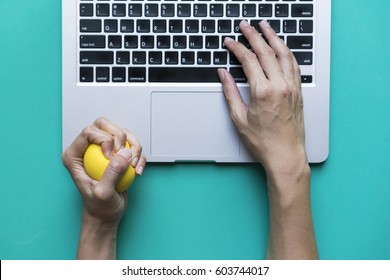 Office Worker Typing Email On Computer, Feels Stressed And Nervous, Holds A Stress Ball In Her Hand