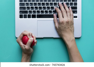 Office Worker Typing Email On Computer, Feels Stressed And Nervous, Holds A Stress Ball In Her Hand